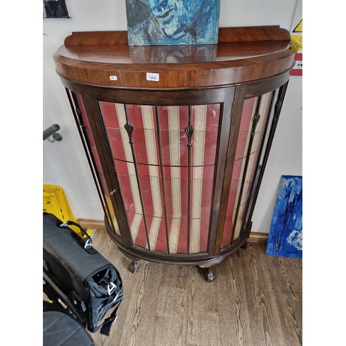 1006 - An early 20th century mahogany bow front display cabinet on ball and claw feet.