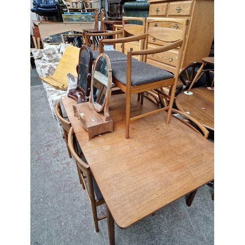 995 - A mid 20th century teak extending dining table and six chairs including two carvers.