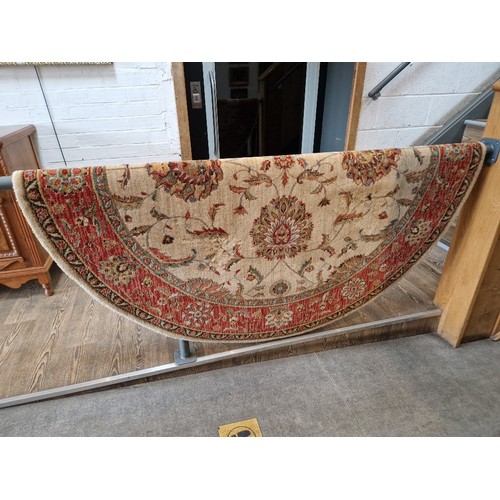 858B - A Chinese wool carpet, cream ground decorated with flowers, diameter 178cm.