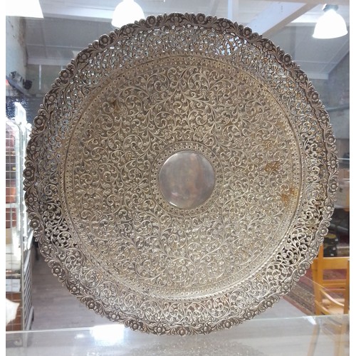 420 - An early 20th century North African/Middle Eastern white metal salver, profusely decorated with flow... 