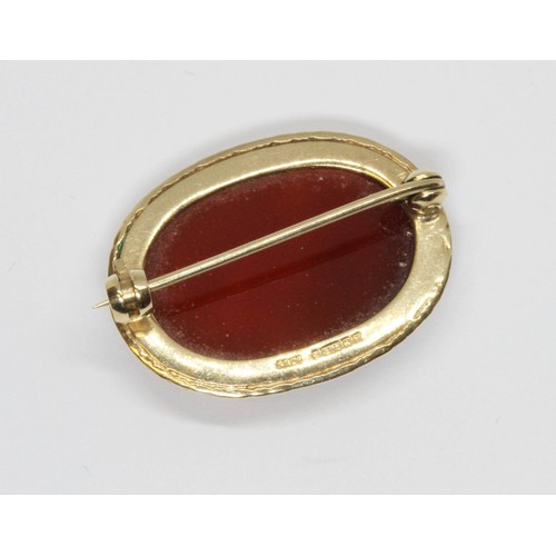 473 - A hallmarked 9ct gold carnelian cabochon brooch, length 28mm, gross weight 5.7g.