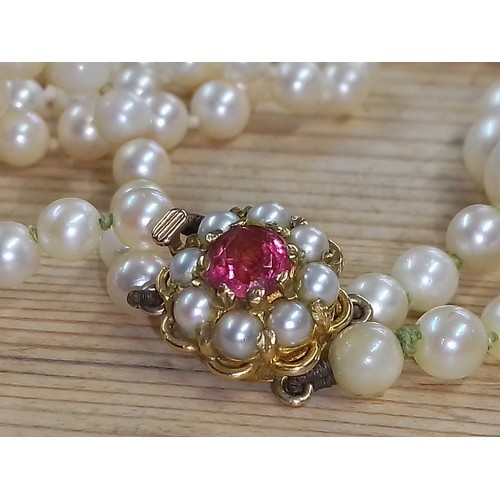 483 - A double strand of graduated cultured pearls, hallmarked 9ct gold split pearl pink stone clasp, leng... 