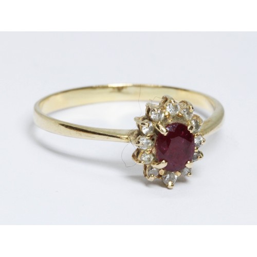 509 - A ruby and diamond cluster ring, the oval cluster measuring approximately 9.5mm x 7.8mm, band marked... 