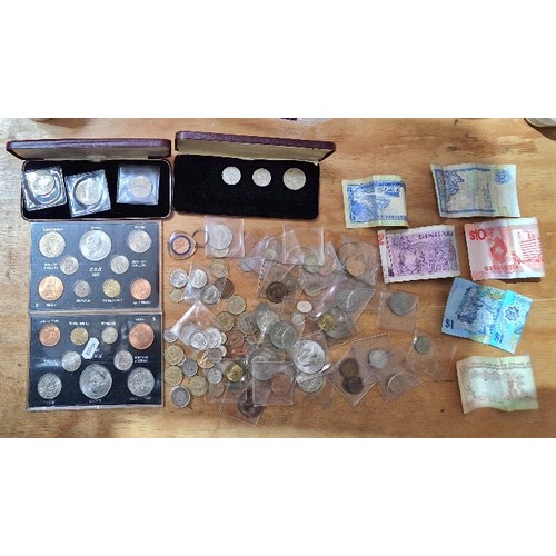 562 - A collection of UK and world coins including cased coin sets and banknotes.