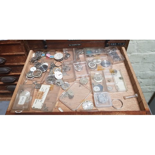 292 - A cabinet of assorted watch spares.