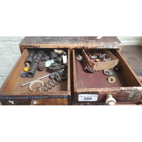 286 - A cabinet of assorted horology spares and tools.