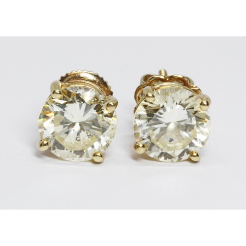 100A - A pair of diamond solitaire ear studs, the round brilliant cut stones weighing approximately 2.99 ca... 