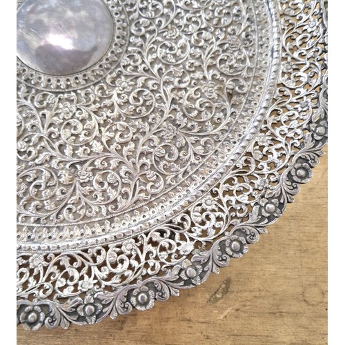 420 - An early 20th century North African/Middle Eastern white metal salver, profusely decorated with flow... 