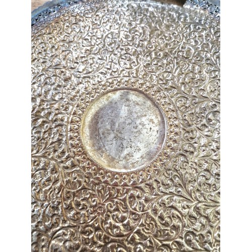 420 - An early 20th century North African/Middle Eastern white metal salver, profusely decorated with flow... 