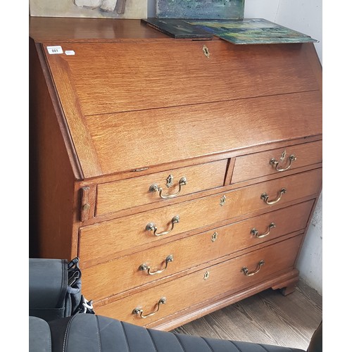 881 - A George III oak bureau standing on ogee bracket feet.