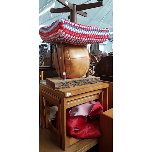 923 - A red cow hide rug, a vintage stool, solid wood coffee table, a leather pouffe and a teak nest of ta... 