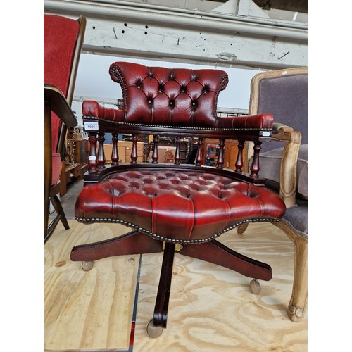 1001 - An oxblood red leather Chesterfield captain's chair.