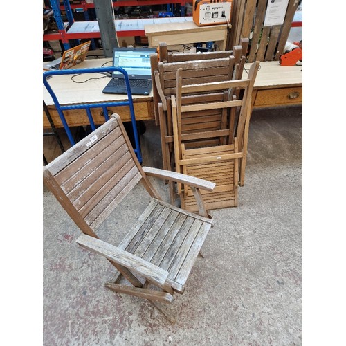 1014 - A set of four folding teak garden chairs.