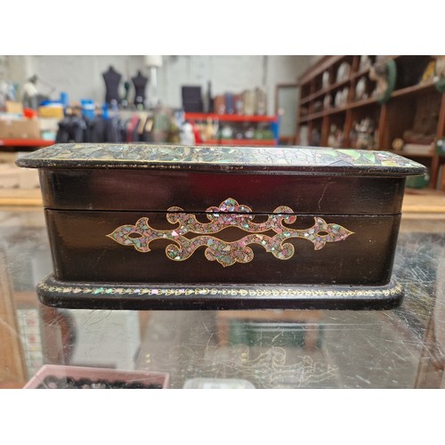 28 - A Victorian black lacquer and mother of pearl inlaid jewellery box with quilted interior and contain... 