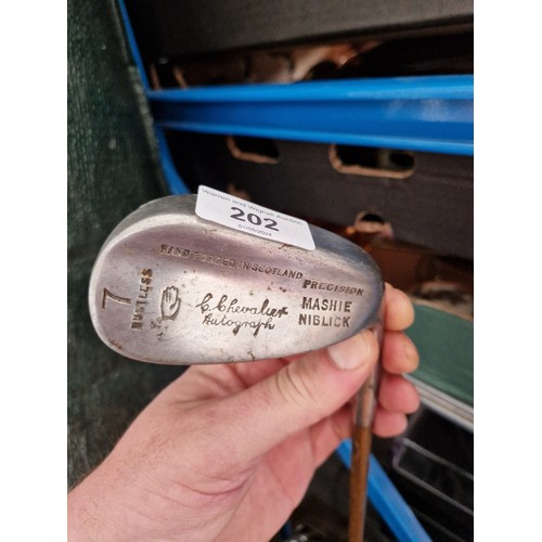 202 - A vintage leather golf back with five hickory shafted clubs.