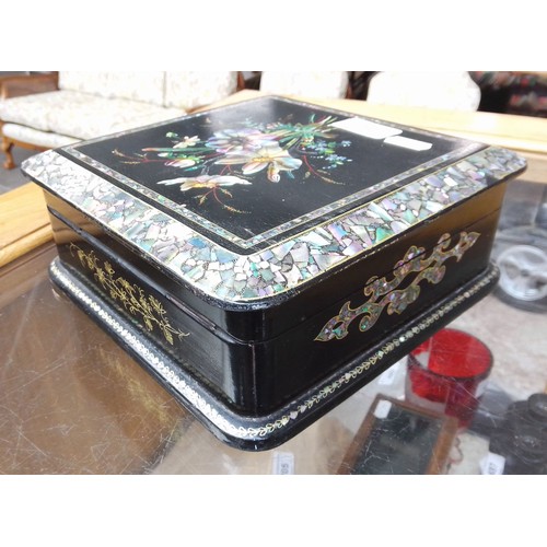 28 - A Victorian black lacquer and mother of pearl inlaid jewellery box with quilted interior and contain... 