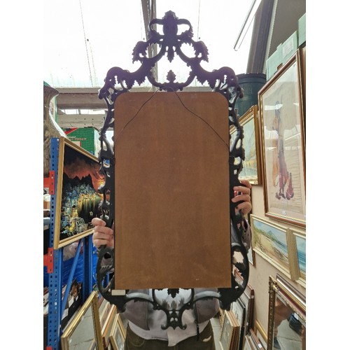 815 - A French style wall mirror, ebonised carved wood frame, 124cm x 59cm (overall).