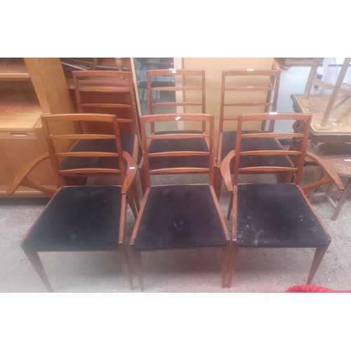 1021 - A set of six mid 20th century teak dining chairs including two carvers.