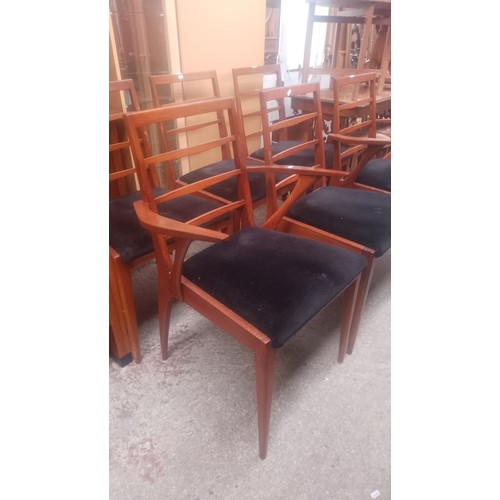 1021 - A set of six mid 20th century teak dining chairs including two carvers.