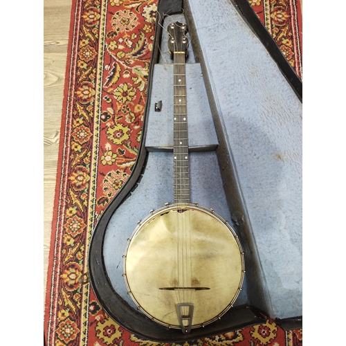 209 - An early 20th century four string banjo, with hard case.