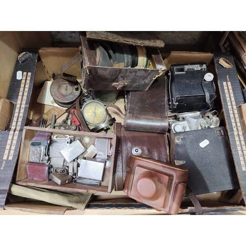 234 - A box of mixed collectables including vintage cameras, cigarette lighters, binoculars, WWII era gas ... 