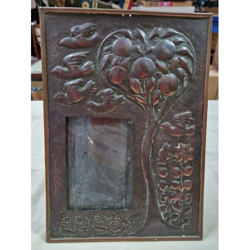 291A - An Arts & Crafts copper picture frame decorated with birds, fruit tree and flowers.