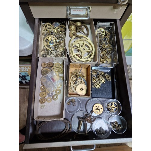 74A - A 15 drawer triumph metal cabinet and contents comprising of clock making spares.