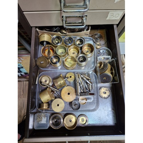 74A - A 15 drawer triumph metal cabinet and contents comprising of clock making spares.