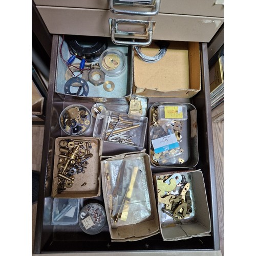 74A - A 15 drawer triumph metal cabinet and contents comprising of clock making spares.