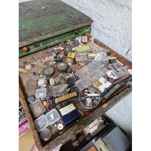 72 - A large green horologist's chest and contents comprising watch and clock making spares.