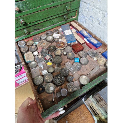 72 - A large green horologist's chest and contents comprising watch and clock making spares.