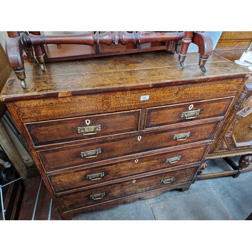 980 - A George III inlaid oak chest of drawers, later handles.