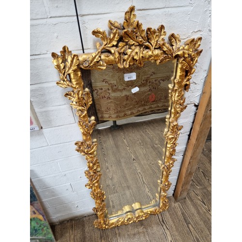 951 - Modern gilt framed mirror, oak leaf and acorn decoration to the frame, 47cm x 105cm (overall).