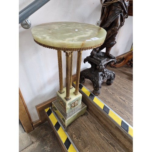 957 - An onyx and brass lamp table/plant stand, four Corinthian column supports, height 80cm.