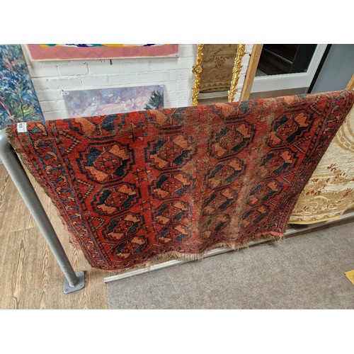 955 - A vintage Middle Eastern hand knotted wool carpet, red ground, geometric pattern, 178cm x 116cm.