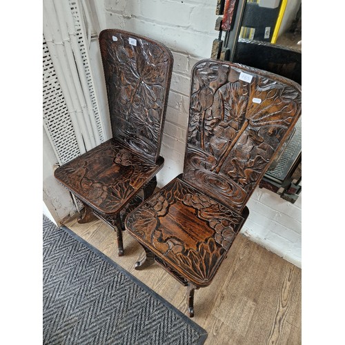 963 - A pair of Eastern carved wood chairs, decorated with flowers.