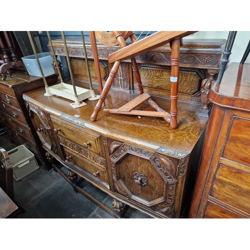 976 - A 1930s carved oak court cupboard.