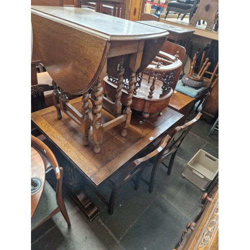 986 - A 1930s oak table and four chairs together with an oak drop leaf table of a similar age.