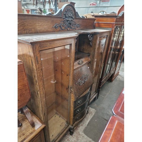 1029 - An Edwardian oak bureau display cabinet with Green Man detail to the top.