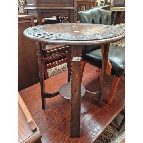 1038 - An early 20th century carved oak occasional table.