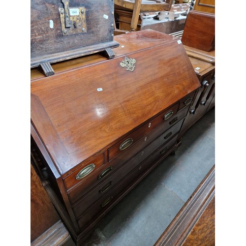 1044 - A George III mahogany bureau with fitted interior, standing on ogee bracket feet.