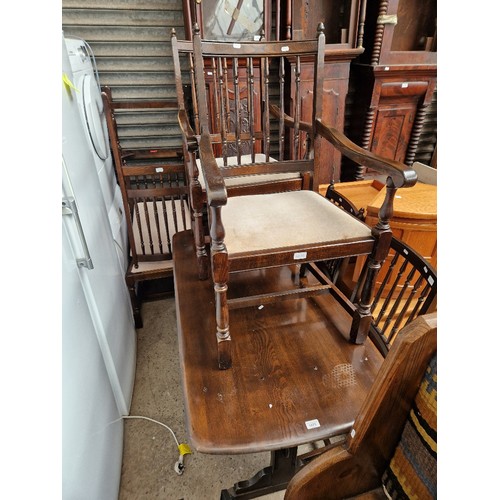 1075 - An Ercol dark elm refectory table and six chairs.