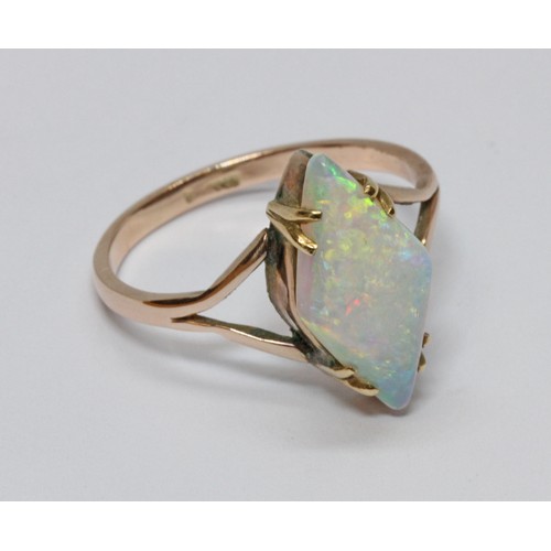 8 - An opal cabochon ring, the lozenge shape stone measuring approximately 16mm x 8mm, yellow band indis... 