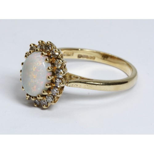 62 - An 18ct gold opal and diamond ring, the central opal cabochon measuring approximately 9.2mm x 7mm, d... 