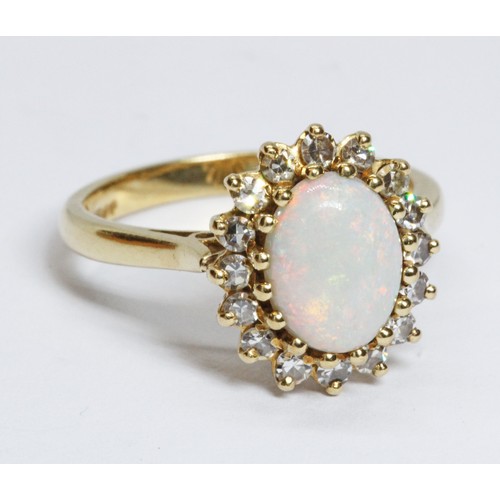 62 - An 18ct gold opal and diamond ring, the central opal cabochon measuring approximately 9.2mm x 7mm, d... 