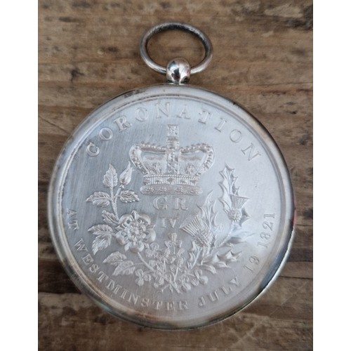 477 - A George IV white metal coronation medal in silver mount, 1821.