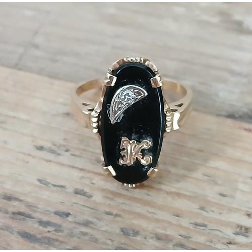 482 - A black onyx and diamond ring, marked '10K', gross weight 3.5g, size N.