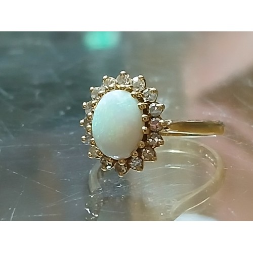 62 - An 18ct gold opal and diamond ring, the central opal cabochon measuring approximately 9.2mm x 7mm, d... 