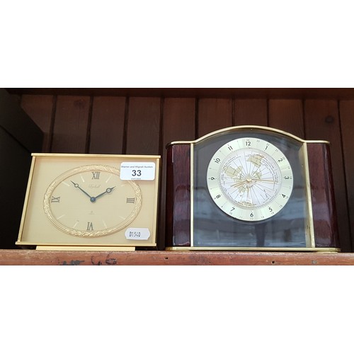 33 - A brass mantel clock by Imhof together with a modern clock featuring a world map