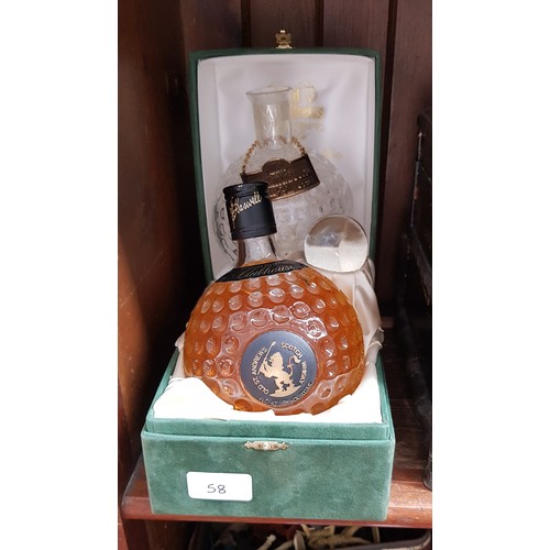 58 - A boxed St. Andrews sealed 21 year old whisky crystal golf decanter together with an empty golf ball... 